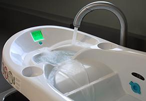 The Daedauls-designed infant bath tub is shown with water running into it from a kitchen faucet.