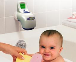 A baby in a bathtub, the spout for which is covered by a temperature sensor and a display showing the temperature of the water.