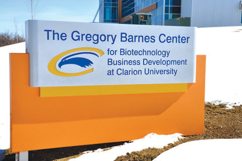 An image of the sign identifying the Gregory Barnes Center for Biotechnology Business Development at Clarion University. The building is visible in the background and there is snow on the ground.