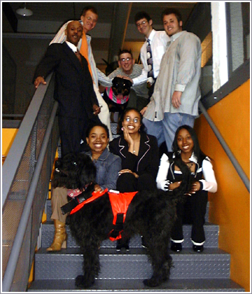 Several students and a couple of dogs pose on the Daedalus staircase.
